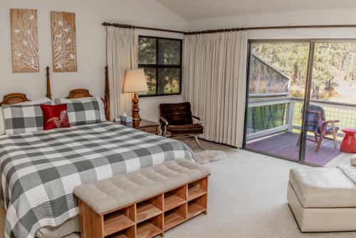 a bedroom with a large bed and a balcony at Swing into Summer at our Mountain Home with a River View in Blairsden