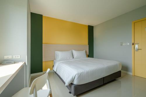 - une chambre avec un lit et un mur jaune et vert dans l'établissement พิลโล่ อินน์ พะเยา Pillow Inn Phayao, à Phayao