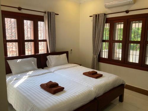 a bedroom with a bed with two towels on it at Lily Pad Boutique Hotel in Siem Reap