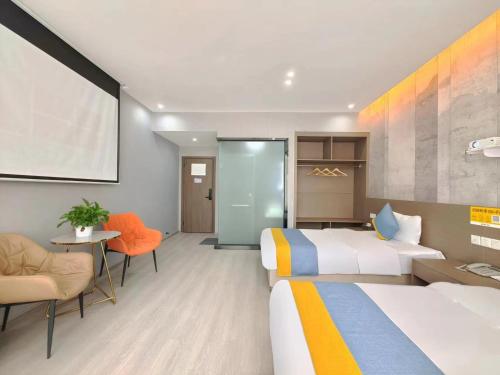 a hotel room with two beds and a table and chairs at Xian Feng Hotel - Tianfu International Airport Branch in Jianyang