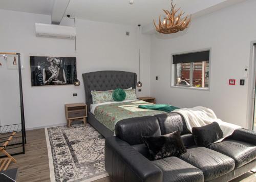 sala de estar con cama y sofá en City Living Apartment Three en New Plymouth