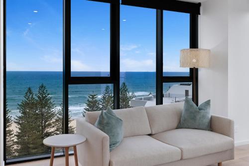 a living room with a couch and a view of the ocean at Sandbar Burleigh in Gold Coast