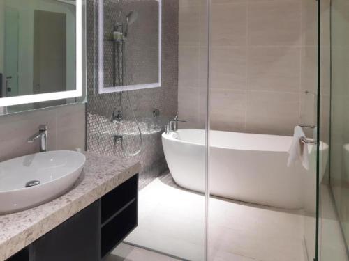 uma casa de banho com uma banheira, um lavatório e um chuveiro em KLCC Ritz Residence STAR em Kuala Lumpur