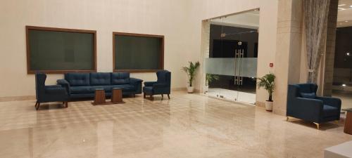 a waiting room with blue chairs in a building at The Orchid Jamnagar in Jamnagar