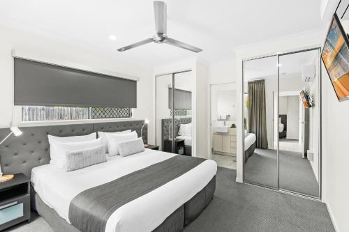 a hotel room with a large bed and a bathroom at Blue Lagoon Villa B in Cairns