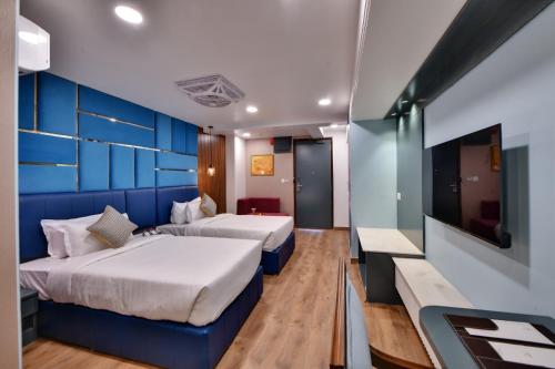 a hotel room with two beds and a tv at The Fern Habitat, Jaipur in Jaipur
