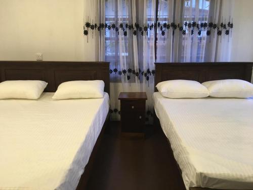 two beds sitting next to each other in a bedroom at Sky Family Villa Ahangama in Ahangama