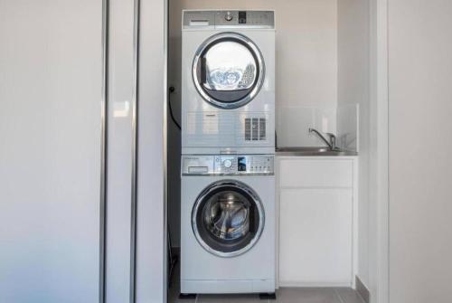 a washer and dryer in a white room at Blue Lagoon Villa B in Cairns