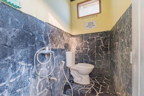 uma casa de banho com um WC e um chuveiro em RedDoorz Syariah at Bumi Eyang Enin Homestay Tasikmalaya em Tasikmalaya