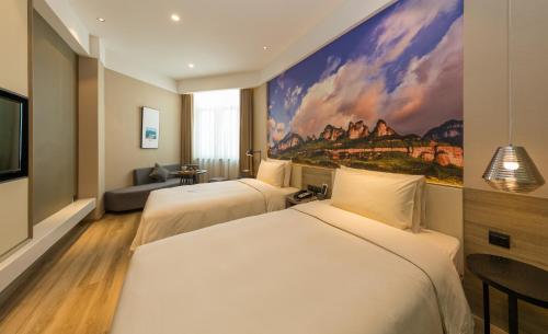 2 Betten in einem Hotelzimmer mit Wandgemälde in der Unterkunft Atour Hotel Chongqing Hongyadong Riverview in Chongqing