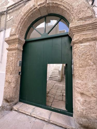 a green door on a building with an arch at AccalmiA in Monopoli