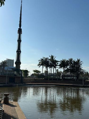 a large body of water with a monument and palm trees at DNA Dream Home in Durban