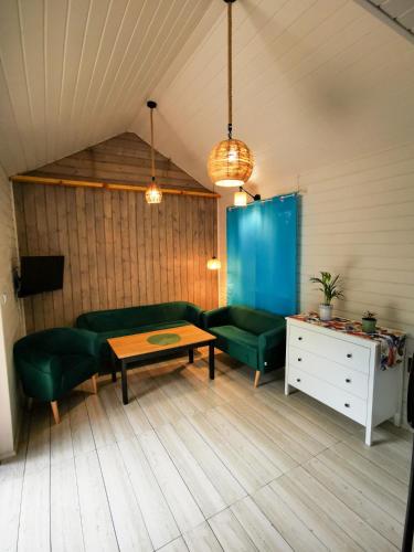 a living room with green furniture and a table at Ostoja Stacze in Stacze