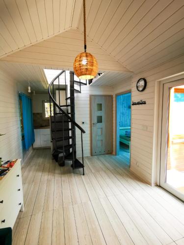 a room with a spiral staircase in a house at Ostoja Stacze in Stacze