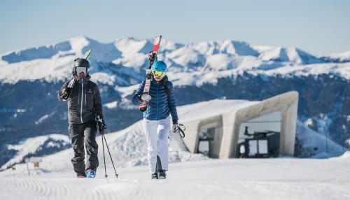 two people standing on top of a snow covered mountain at Pension Panorama in San Lorenzo di Sebato