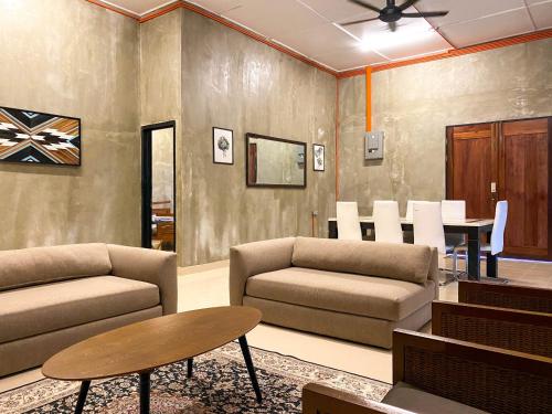 uma sala de estar com dois sofás e uma mesa em TERATAK ZAINAB GUEST HOUSE KOTA BHARU em Kota Bharu