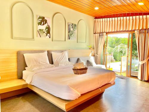 um quarto com uma cama grande e uma cesta. em สต็อกโฮม เขาใหญ่ (StockHome Khao Yai) em Khanong Phra