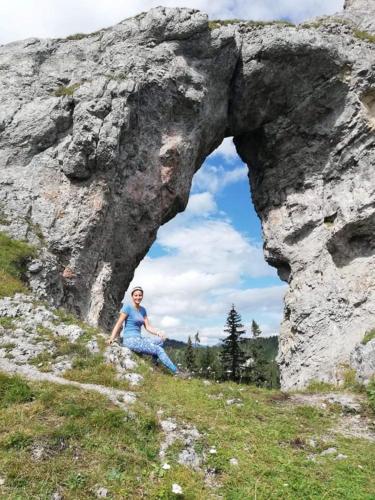 a woman sitting in front of a rock formation at Chata Smrekovica in Liptovský Ján