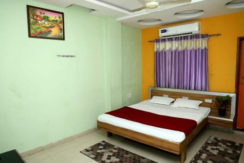 ein Schlafzimmer mit einem Bett und einem lila Fenster in der Unterkunft Hotel Padmapani Park Fardapur in Phardāpur