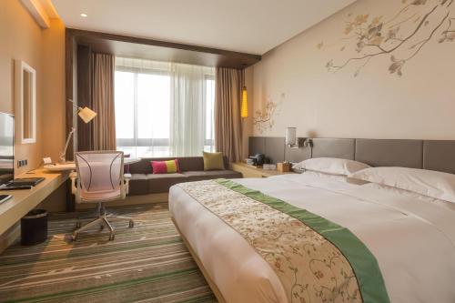 Habitación de hotel con cama grande y escritorio. en Hilton Garden Inn Xi'an High-Tech Zone, en Xi'an