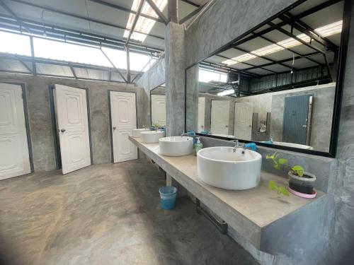 a large bathroom with three sinks and two mirrors at Baanrimfai Homestay in Ban Thung Sang