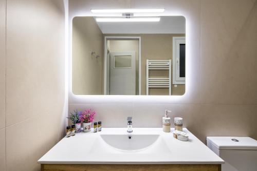 a bathroom with a white sink and a mirror at Renovated apartment near Acropolis in Athens
