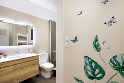 a bathroom with a sink and a toilet with butterflies on the wall at Renovated apartment near Acropolis in Athens