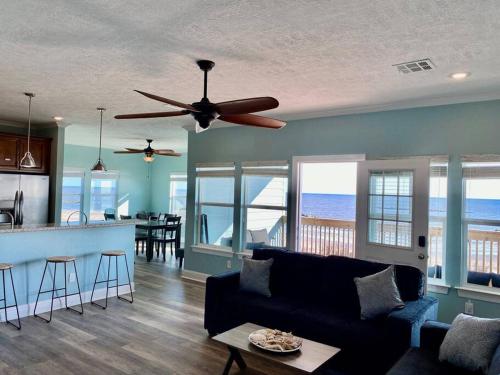 a living room with a couch and a ceiling fan at OceanFront home near HollyBeach in Cameron