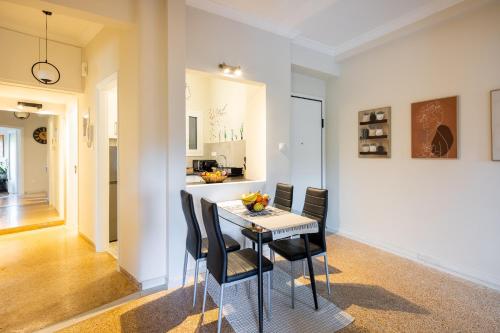 a dining room with a table and black chairs at Renovated apartment near Acropolis in Athens