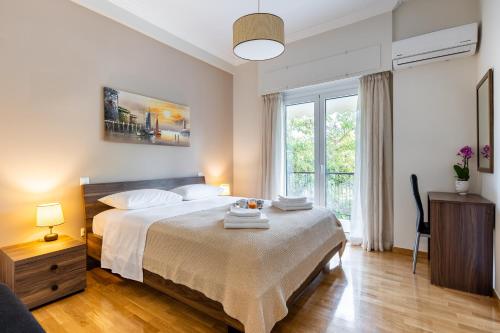 a bedroom with a bed and a large window at Renovated apartment near Acropolis in Athens