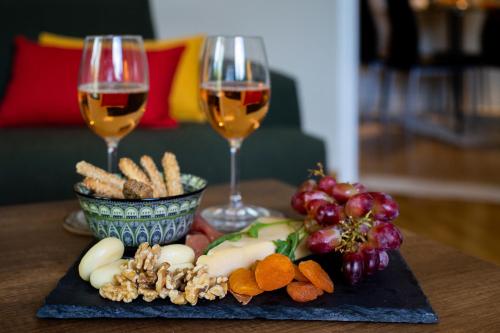 two glasses of wine and a plate of food on a table at Renovated apartment near Acropolis in Athens