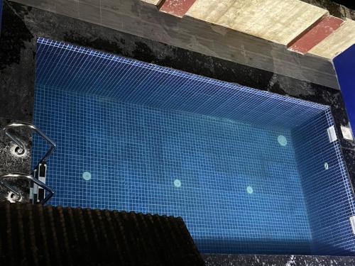 a blue pool of water next to a shower at Ladakh House- 3 BHK Ladakh themed Villa near Matheran in Neral