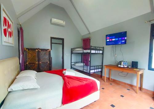 a bedroom with a bed with a television and a desk at Degung Hillside in Bogor