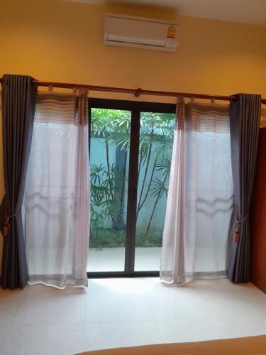a window with white curtains in a room at Roland Villa in Koh Samui 