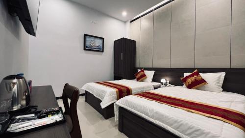 a hotel room with two beds and a television at Huy Hoàng Hotel in Phan Thiet