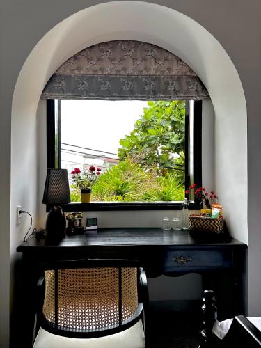 a window with a black desk in front of a window at Moon Homestay in Thôn Kim Long (1)