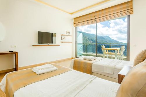 a hotel room with two beds and a large window at infinity mountain in Kalkan