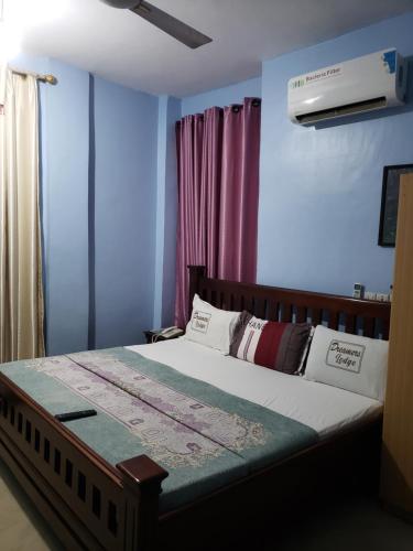 a bedroom with a bed with blue walls at Dreamers Lodge in Prampram