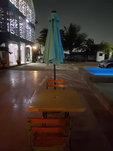 an umbrella sitting on a table in front of a building at Dreamers Lodge in Prampram