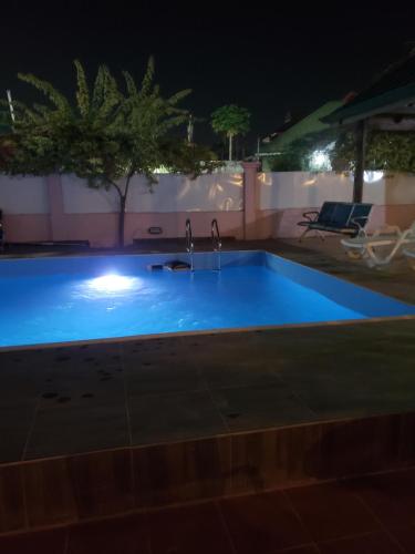 a swimming pool at night with two faucets at Dreamers Lodge in Prampram
