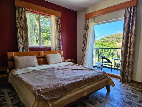 a bedroom with a bed and a balcony at Ushpav Villa in Cap Malheureux