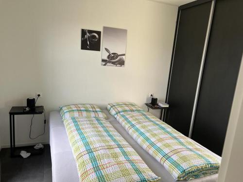 1 dormitorio con 2 almohadas en Enkhuizer Strand Chalet ZweiZeit Dritte Reihe Haus Nr 260, en Enkhuizen