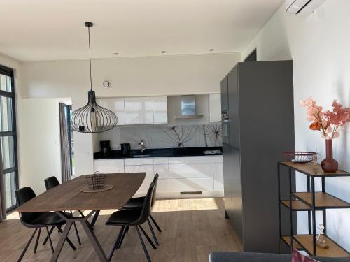 a kitchen and dining room with a table and chairs at Enkhuizer Strand Chalet Möwennest Zweite Reihe Haus Nr 261 in Enkhuizen