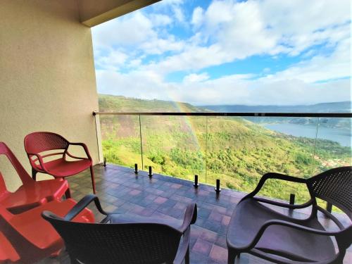 パンチガニにあるVinayaka Stays - Infinity Pool and Breathtaking Valley Viewの椅子と山の景色が見えるバルコニー
