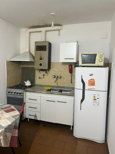 Elle comprend une petite cuisine équipée d'un réfrigérateur et d'un évier. dans l'établissement Departamento Centro Villa Carlos Paz, à Villa Carlos Paz