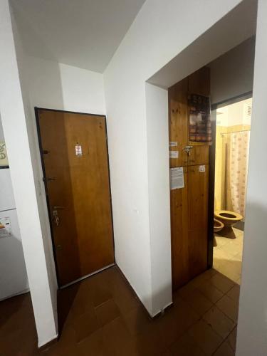 - un couloir avec deux portes en bois et des toilettes dans l'établissement Departamento Centro Villa Carlos Paz, à Villa Carlos Paz