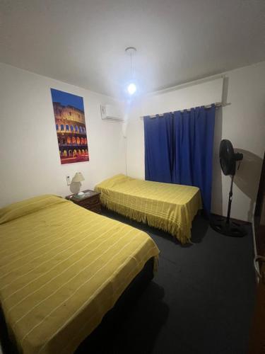 - 2 lits dans une chambre d'hôtel avec des draps jaunes dans l'établissement Departamento Centro Villa Carlos Paz, à Villa Carlos Paz