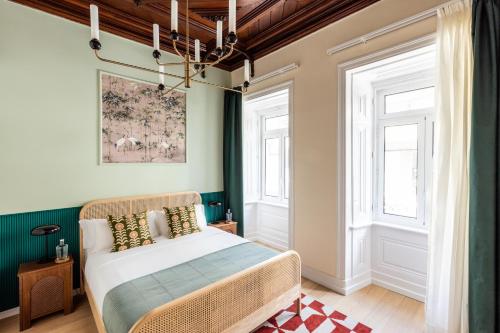 a bedroom with a bed and two windows at Haws Lisboa in Lisbon