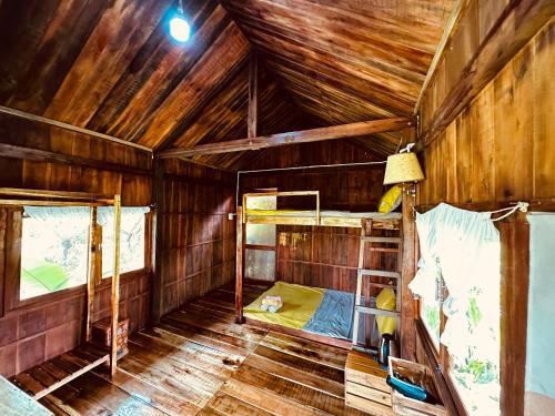 a room with two bunk beds in a wooden cabin at Bungalow - Farmstay Hoa Rừng U Minh in Cà Mau