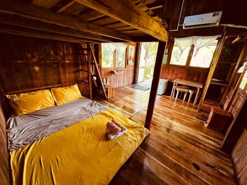 Bett in einem Zimmer mit einer Person, die darauf liegt in der Unterkunft Bungalow - Farmstay Hoa Rừng U Minh in Cà Mau